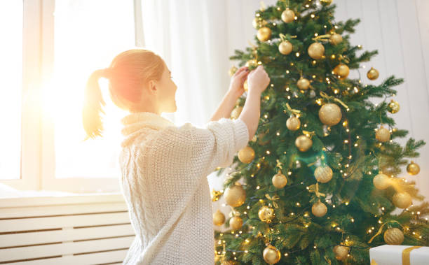istock happy woman decorated  Christmas tree 880311466