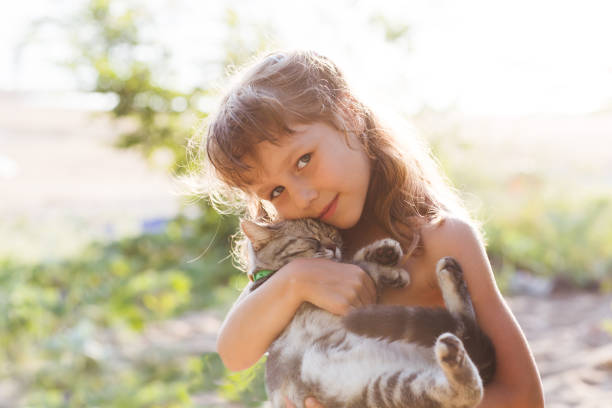 istock Happy child with cat outdoors. 880317150