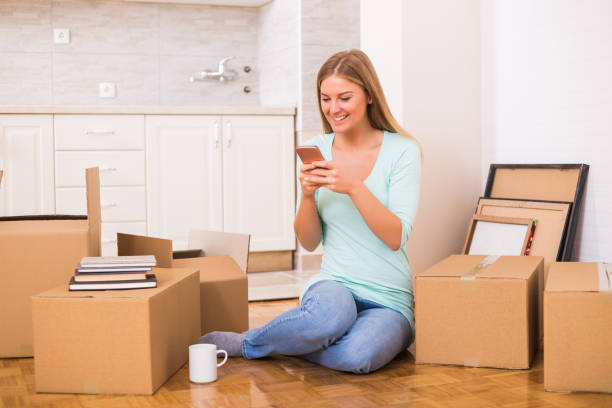 istock Woman using phone in her new home 880323488