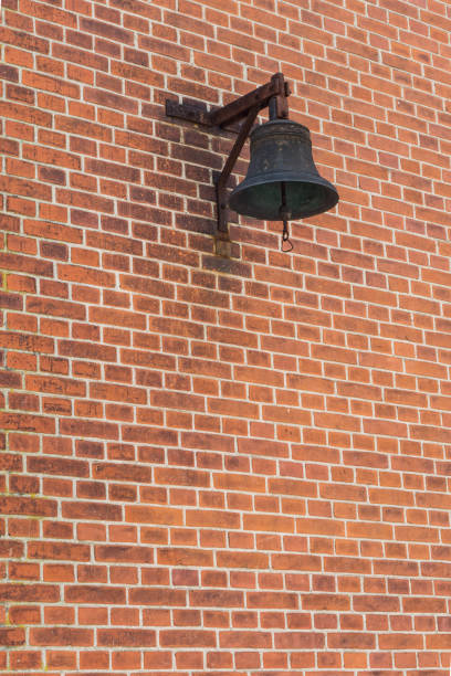 istock Metal bell on a red brick wall 880328346