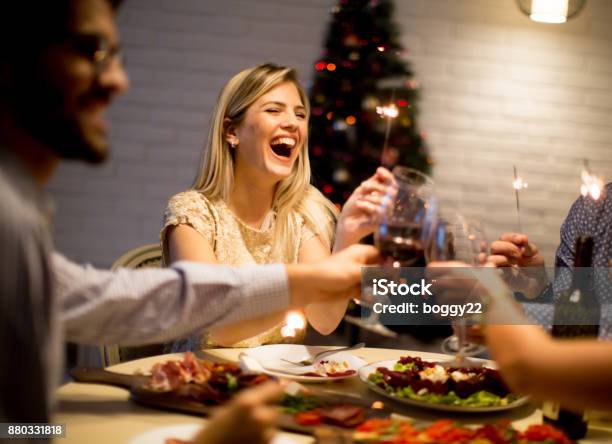 Gente Joven Celebrando El Año Nuevo Y Beber Vino Tinto Foto de stock y más banco de imágenes de Navidad