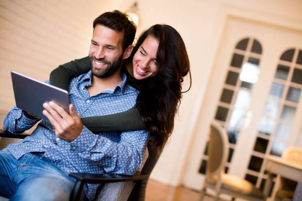istock Young couple sitting in the living room and using tablet 880334676