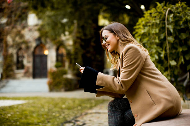 istock Modern woman using mobile phone at autumn outdoor 880335022