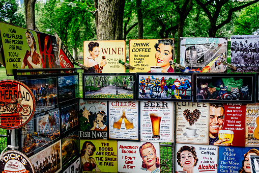 Retro humorous covers at a vendor's stand on Literary Walk, also known as The Mall, in Central Park, Manhattan, New York City, on a summer's day.