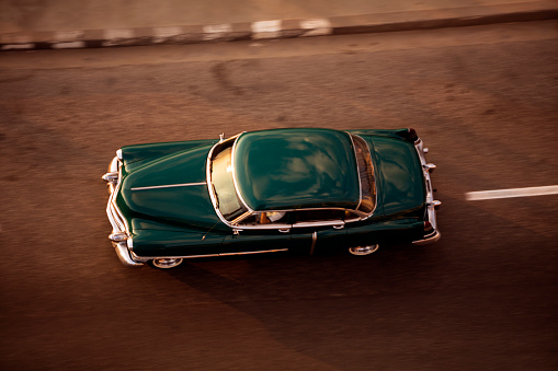 High angle view of an old American car goes down the street in Havana, Cuba