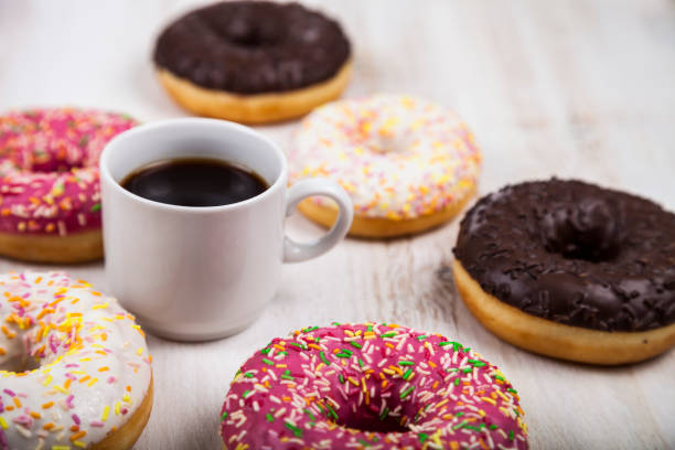 пончики и чашка кофе крупным планом - cream sprinkles food and drink freshness стоковые фото и изображения