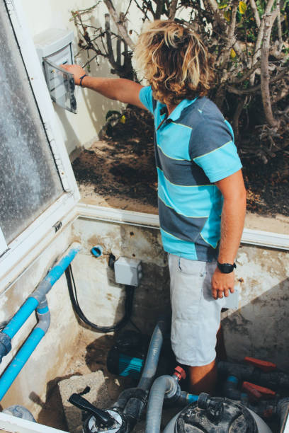 istock Male pool cleaner checking water pump 880344102