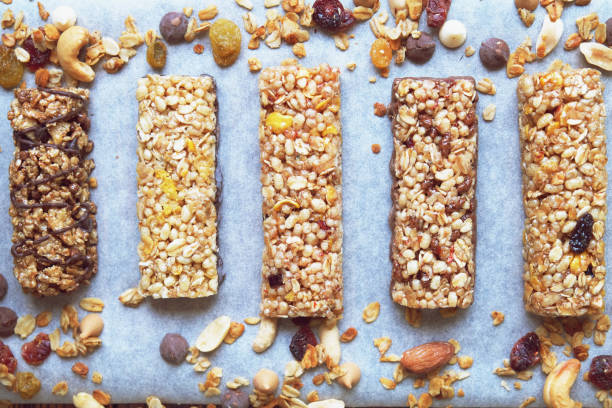 istock Five various nutritious high protein granola power bars laid on the wooden table, mixed nuts, dry fruits and chocolate, healthy superfood. Top View 880344718
