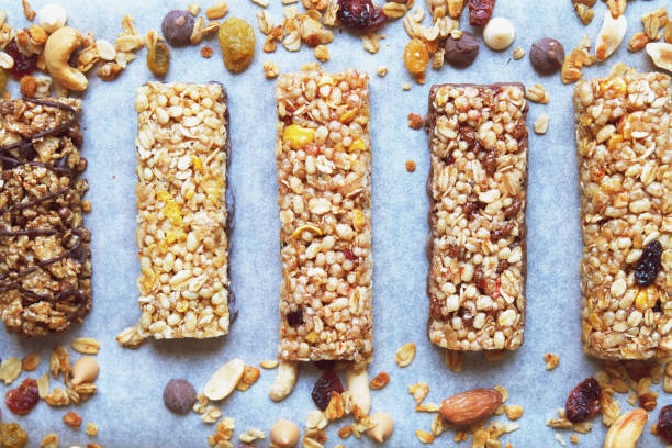 istock Five various nutritious high protein granola power bars laid on the wooden table, mixed nuts, dry fruits and chocolate, healthy superfood. Top View 880344720