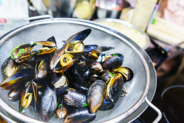 istock Boiled mussels with spices and herbs close-up. Soft selective focus. 880353326