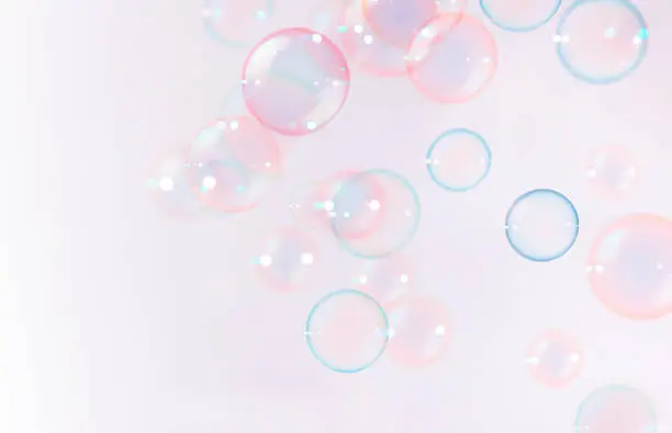 Soap bubbles floating on pink background