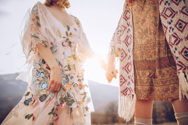 Female couple holding hands Two hippie women holding each other hands in nature. bohemian fashion stock pictures, royalty-free photos & images