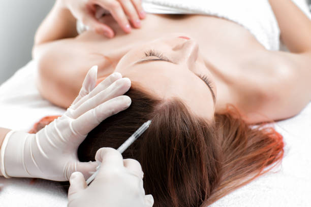 istock Needle mesotherapy. Cosmetic been injected in woman's head. 880379470