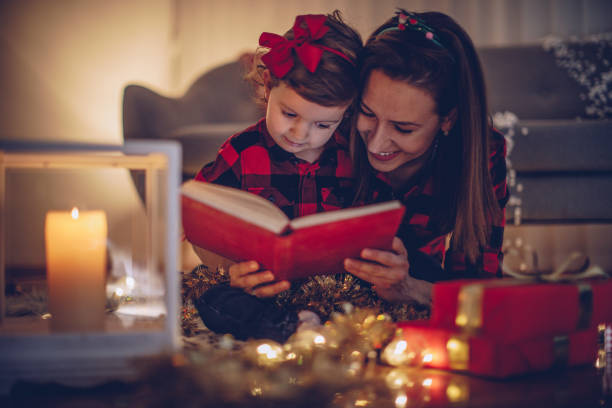 istock Mom reading a book to a daughter 880382682