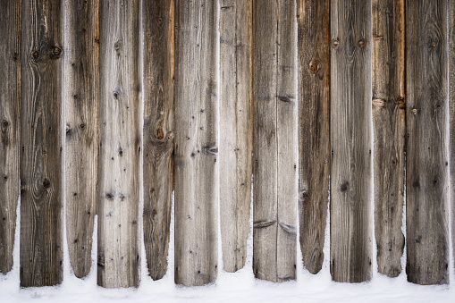 Old vintage wood wall with snow. Winter and christmas background. Wood planks, boards are old with a beautiful rustic look. Nice studio lighting and elegant vignetting to draw the attention.