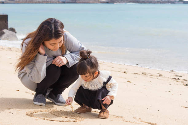 istock Mother & Daughter Play in the Sand 880386548