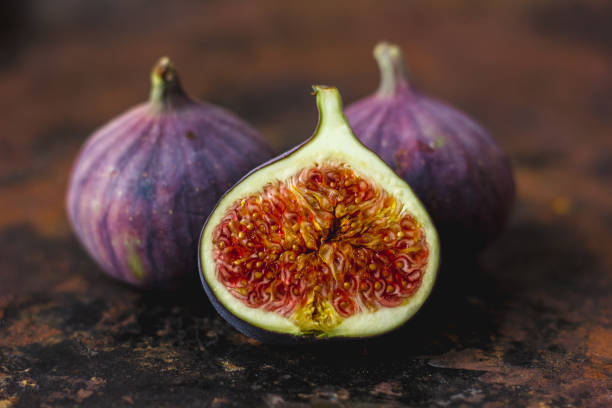 istock Half of fresh ripe figs on rusty metal surface. 880388754