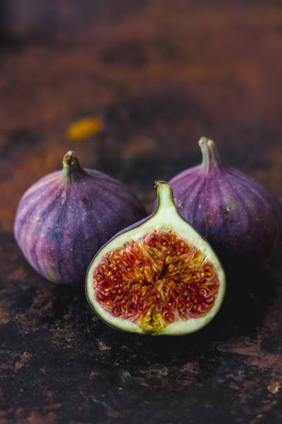 istock Half of fresh ripe figs on rusty metal surface. 880388844