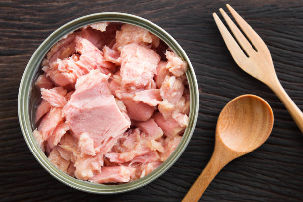 canned soy free albacore white meat tuna packed in water on wood table background. dark tone - tuna chunks imagens e fotografias de stock