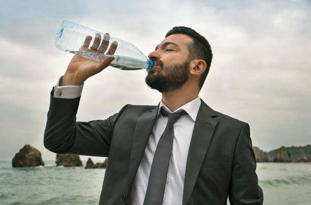 istock Thirsty Businessman Drinking Water in the Seaside 880397898