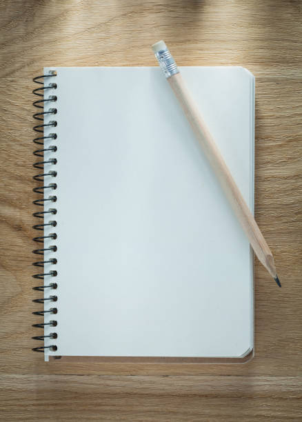 istock Spiral notepad pencil on wooden board 880401004