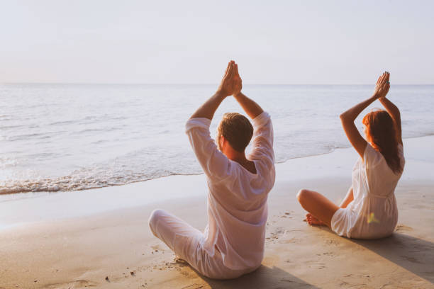 istock group meditation, yoga on the beach 880404554