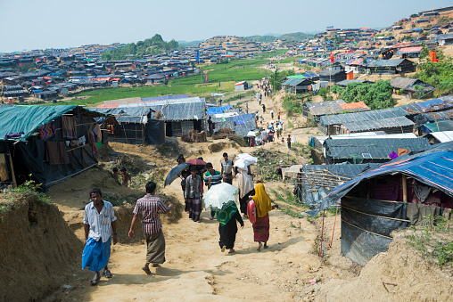 Jamtoli refugee camp, Bangladesh - October 26, 2017: Rohingya Muslims walk down a dirt lane in the crowded Jamtoli refugee camp near Cox's Bazar, Bangladesh.