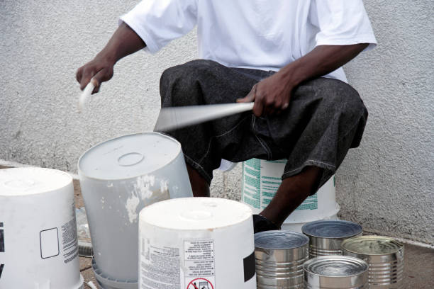 Inventive Drummer Young African American man beating out the rhythm on plastic container bucket drums. Horizontal. drummer stock pictures, royalty-free photos & images