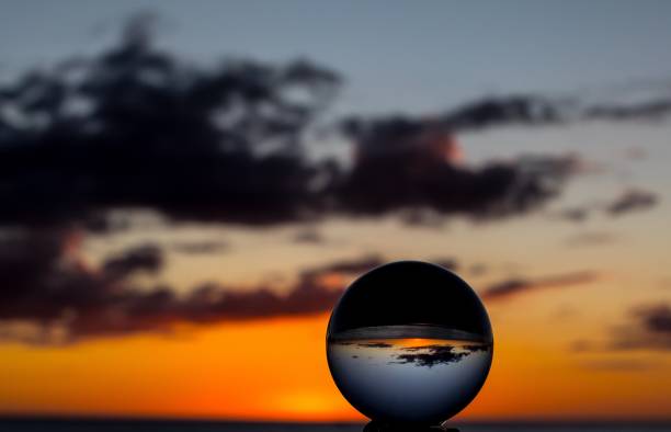 istock Orange sunset with clouds and glass ball 880429330