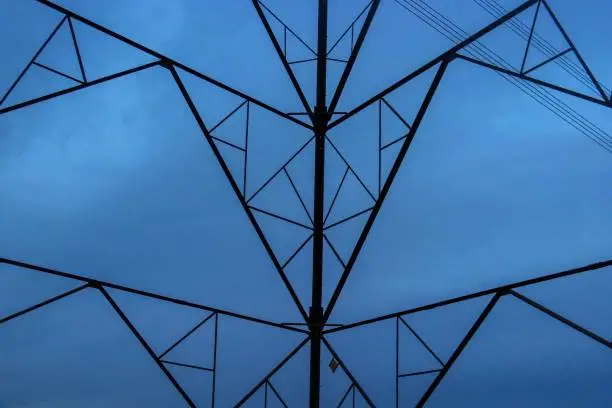 An electricity pylon viewed from inside to form a triangular pattern