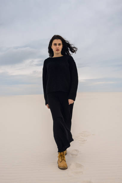 istock Resolute girl, in black, walks through the desert 880443672