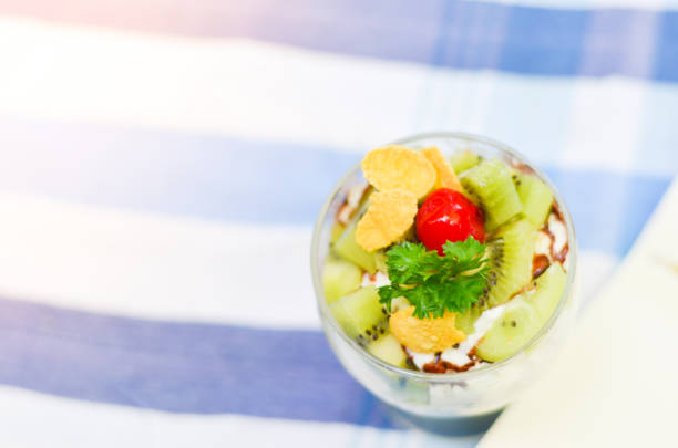 istock Kiwi corn flakes and vegetables with yogurt on grass cup,paper note and pencil,holiday time picnic in the garden,select focus. 880444076