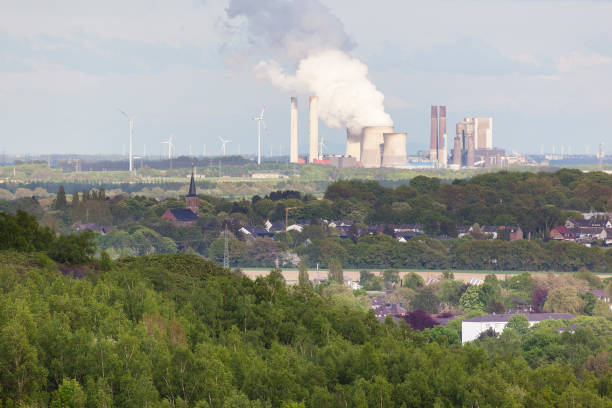 istock Distant Power Station in Rural Landscape surrounded by Wind Turbines 880444194
