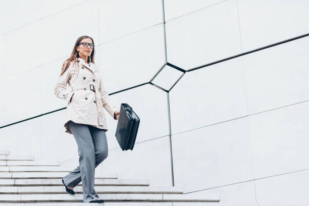 istock Businesswoman walking down a staircase 880444448