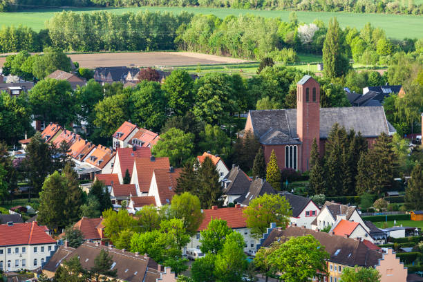 High angle view of little village High angle view of a little west German village with a church surrounded by trees near Aachen. alsdorf stock pictures, royalty-free photos & images