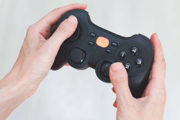 istock A woman is holding a joystick. Gamepad in hands on a white background 880462950