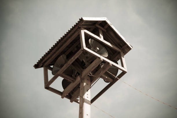 istock Old public loudspeakers broadcast on high tower with long distance tower 880465694