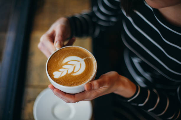 lady's hände halten tasse mit herzförmigen sth - cappuccino stock-fotos und bilder