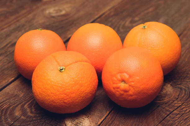 istock Fresh juicy oranges on the wood background 880486120