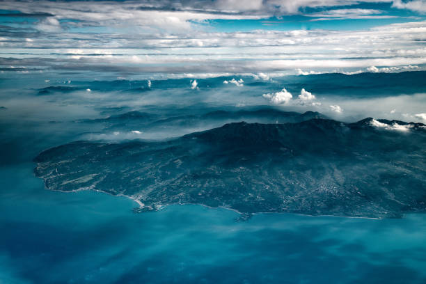 The city of Taipei, the capital of Taiwan, seen from an airplane during the afternoon. Some fog hanging over the city.