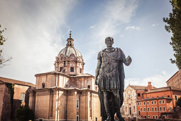 Julius Caesar statue in Rome Julius Caesar statue with church of Saint Luca e Martina on the background - a bronze copy of the statue in the Capitol emperor stock pictures, royalty-free photos & images