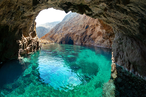 Natural rocky arch with clear transparent waters, in Tragonissi islet, Myconos, Greece