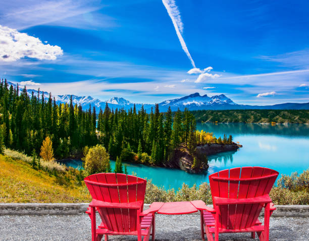 Lake with turquoise water Warm September in the mountains of Canada. Two red comfortable loungers by the Abraham lake with turquoise water. Concept of ecological and active tourism indian summer stock pictures, royalty-free photos & images