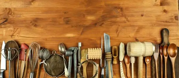 Old kitchen utensils on a wooden board. Sale of kitchen equipment. Chef's tools