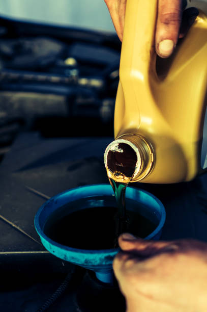 istock man pours motor oil into the car 880547358