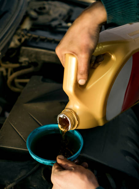istock man pours motor oil into the car 880547402