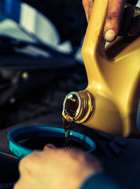 istock man pours motor oil into the car 880547420