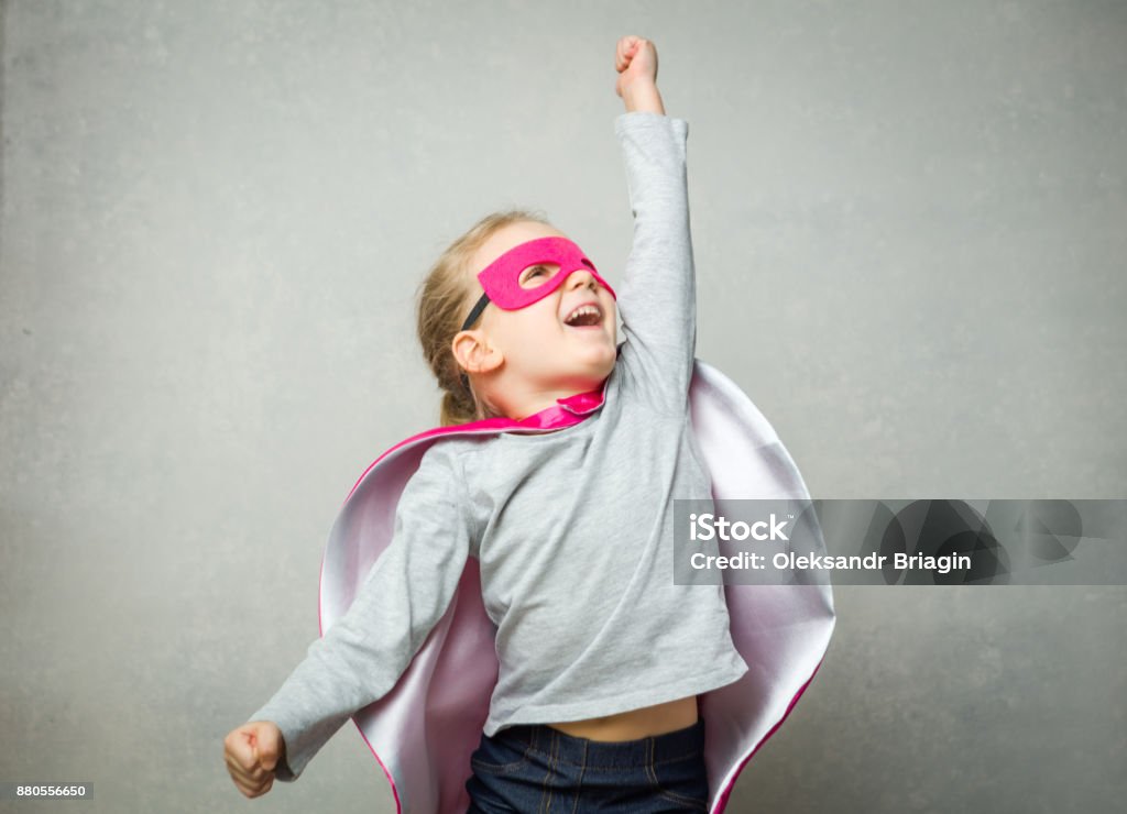 Little girl pretending that she is flying wearing a cloak and mask Child Stock Photo