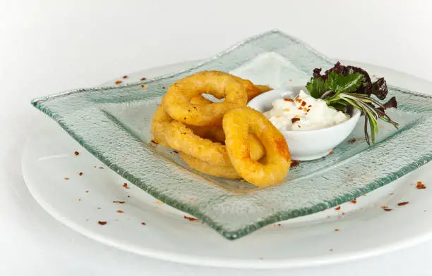 Fried Breaded Onion Rings with sauce on white background