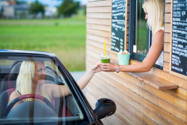 istock Drive-in caffe female clerk with smoothie 880565170